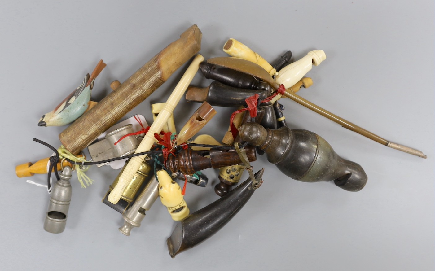 A collection of various collectable 19th century whistles, including bone, pewter, horn, ebony, brass and some ivory.